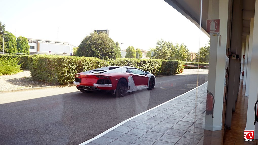 New Lamborghini Aventador cars passing outside the museum windows