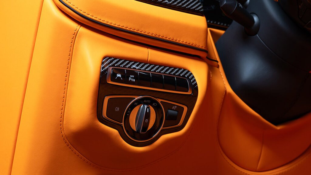 Mercedes-Benz G63 Lava Orange interior detail with gloss carbon switch trim