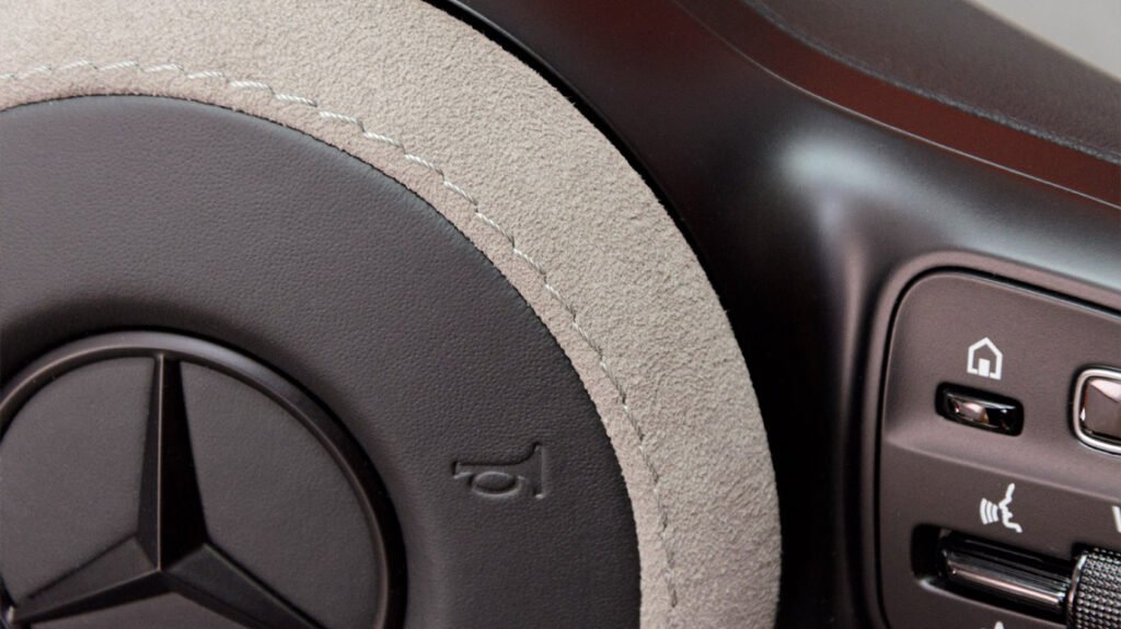Close-up of grey Alcantara and control area on Mercedes-AMG G63 steering wheel